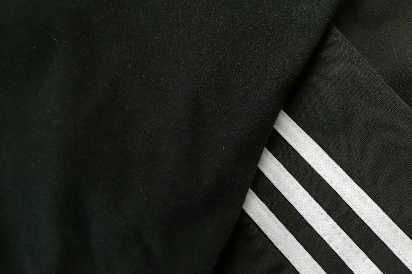 Three parallel white stripes on black fabric.