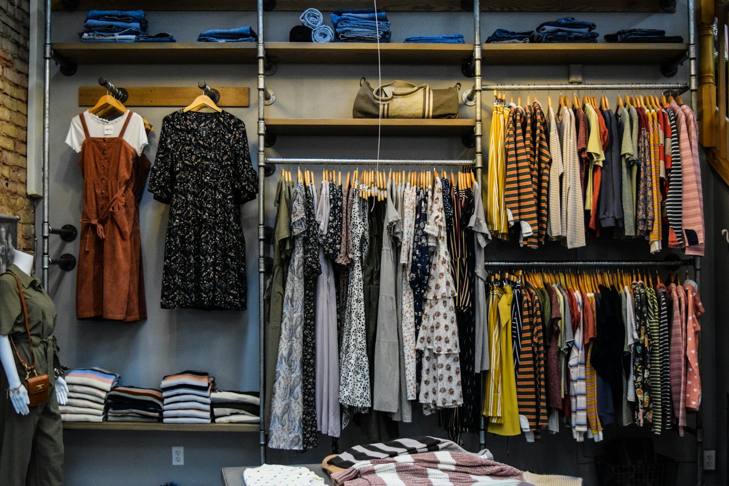 Women's clothing boutique with dresses and jumpsuits on display.